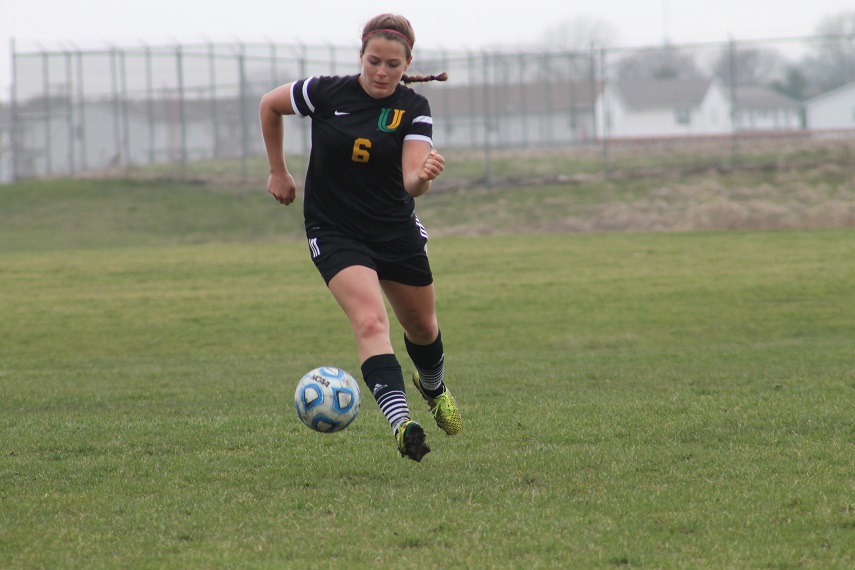 Junior Molly Day dribbles the ball up the field against Intercity rival Bloomington High School. The Pioneers won 7-0.