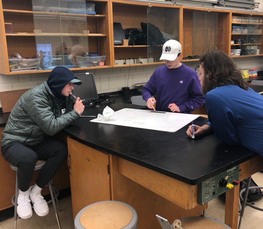Physics teacher Aaron Pacheco guides Jack Lindstrom and Sean Supan through one of many inquiry-based projects. 